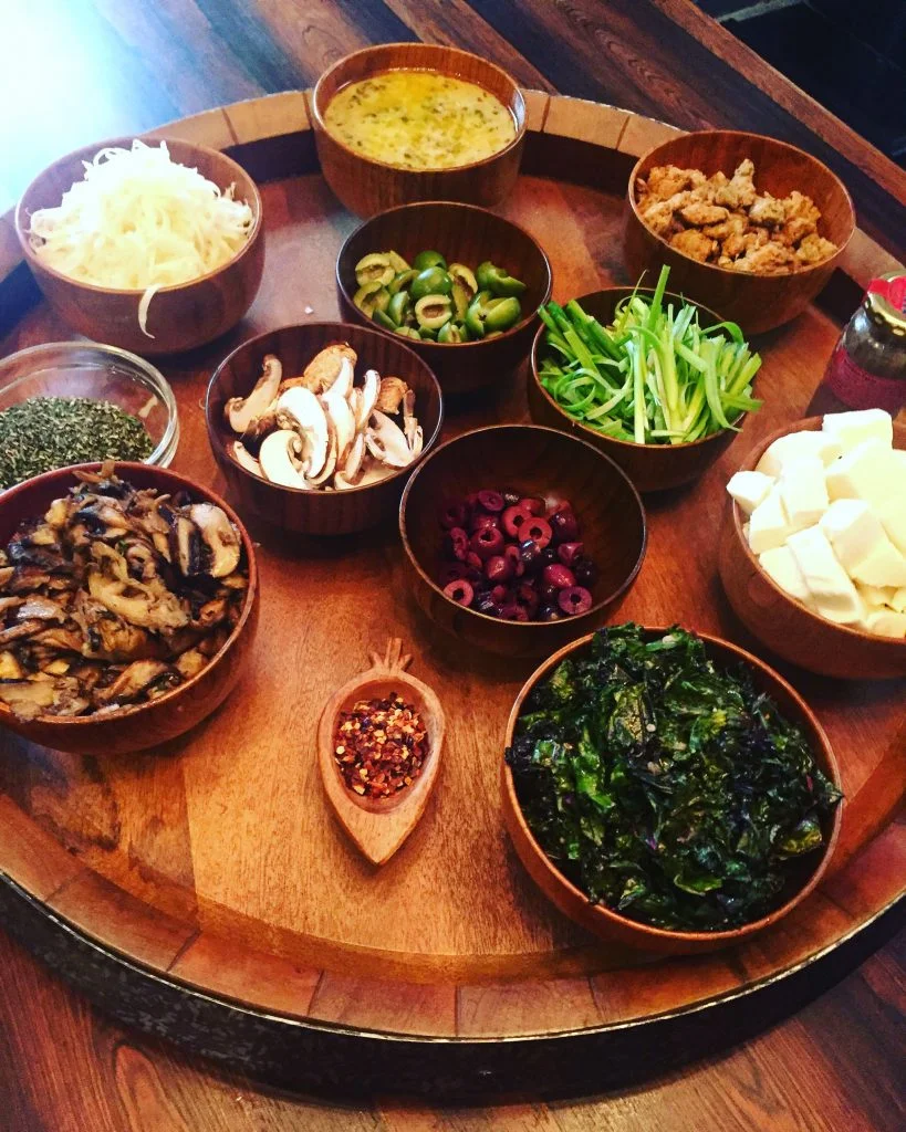 Here it is, all my prepared toppings. Olives, sauteed kale, cheese, sautéed mushrooms, herbs, scallions, sausage and my favorite white sauce.