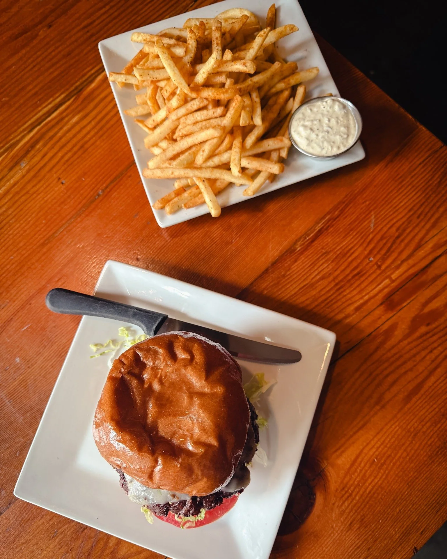 Burger, old bay fries, and a side of our house-made tarter sauce for dipping (or double-dipping, we&rsquo;re not judging). Crisp edges, soft bun, cold drink nearby, exactly how midweek should taste.