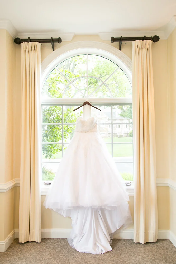 Wedding dress hanging in the window of Evergreen Country Club | Northern Virginia Wedding Photography