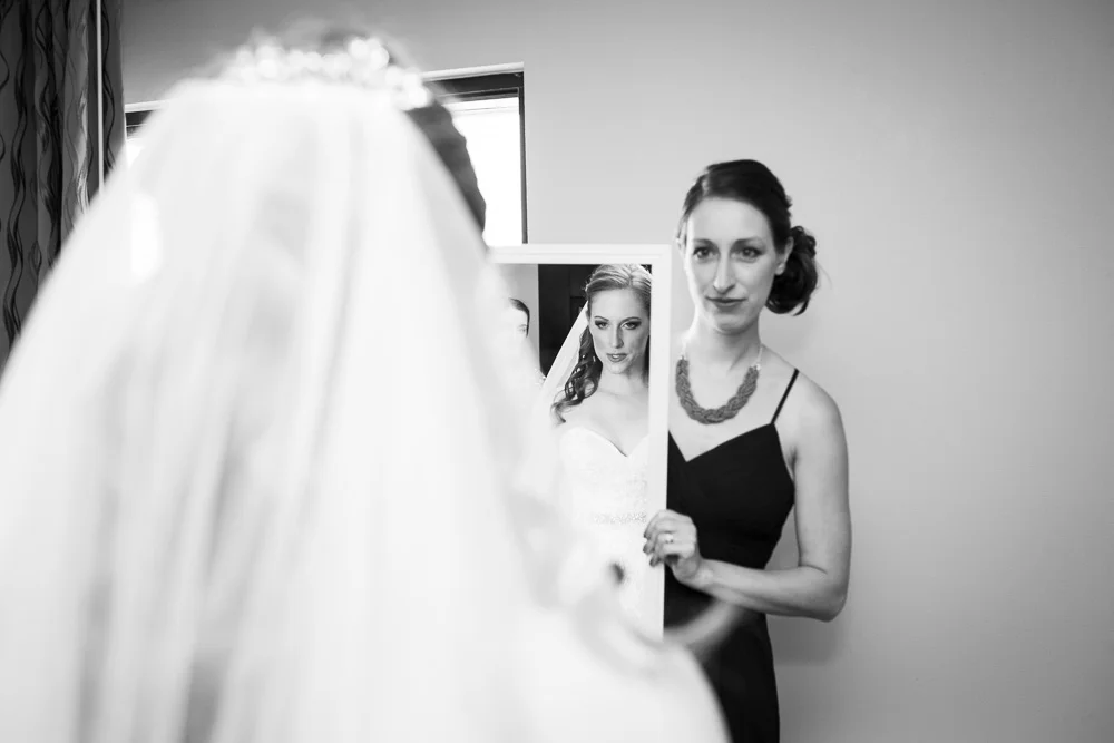 Bride looking in the mirror while getting ready for the wedding day | Documentary Rochester Wedding Photography