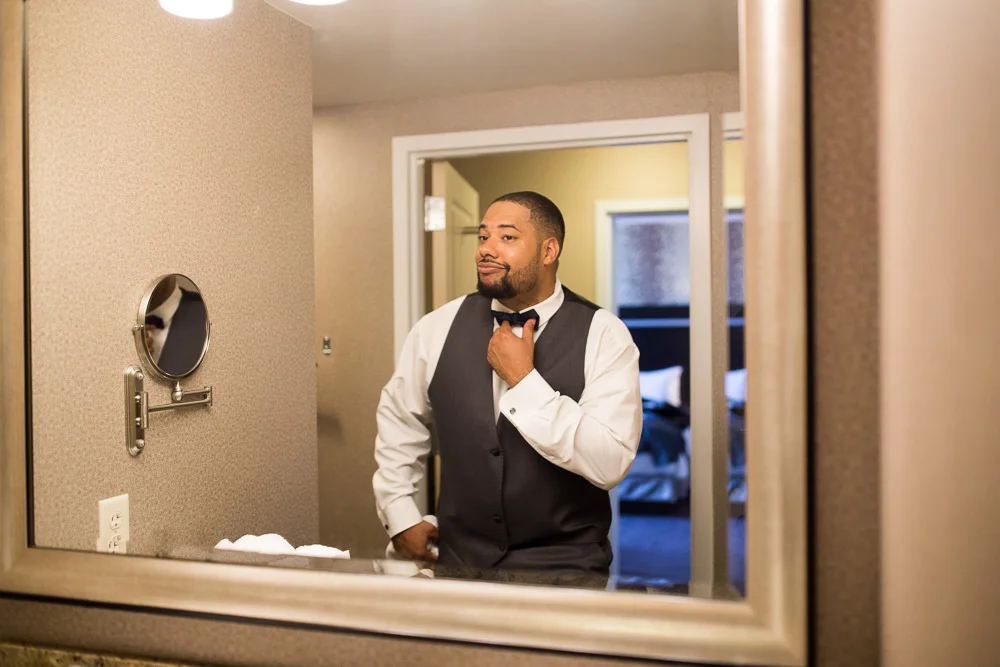 Groom looking in the mirror | Rochester Wedding Photography