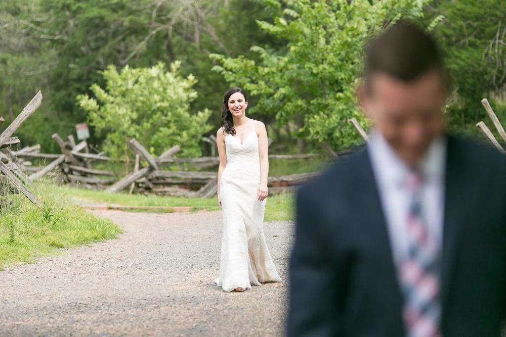 Smiling bride approaching the groom for the First Look photos | Stone Bridge at Manassas National Battlefield Park