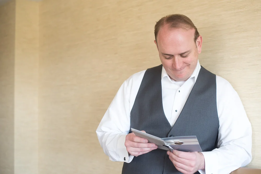 Groom reading a sweet letter from the bride before the wedding ceremony | Westin Washington Dulles Airport Wedding | Candid Wedding Photographer in Herndon, VA