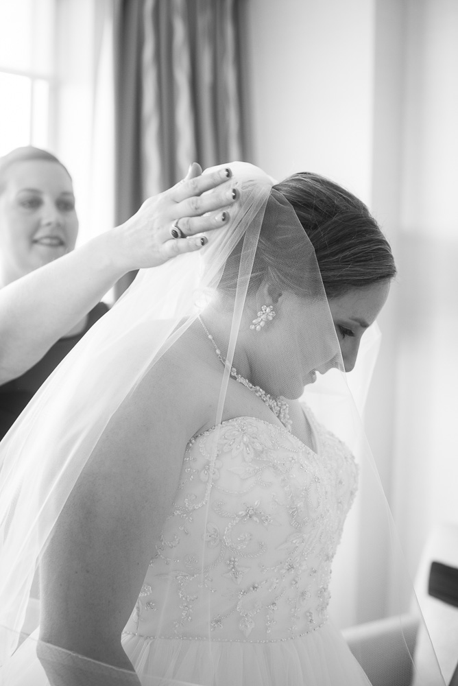 Bridesmaid helping the bride put on her veil | Documentary wedding photography in Herndon, Virginia