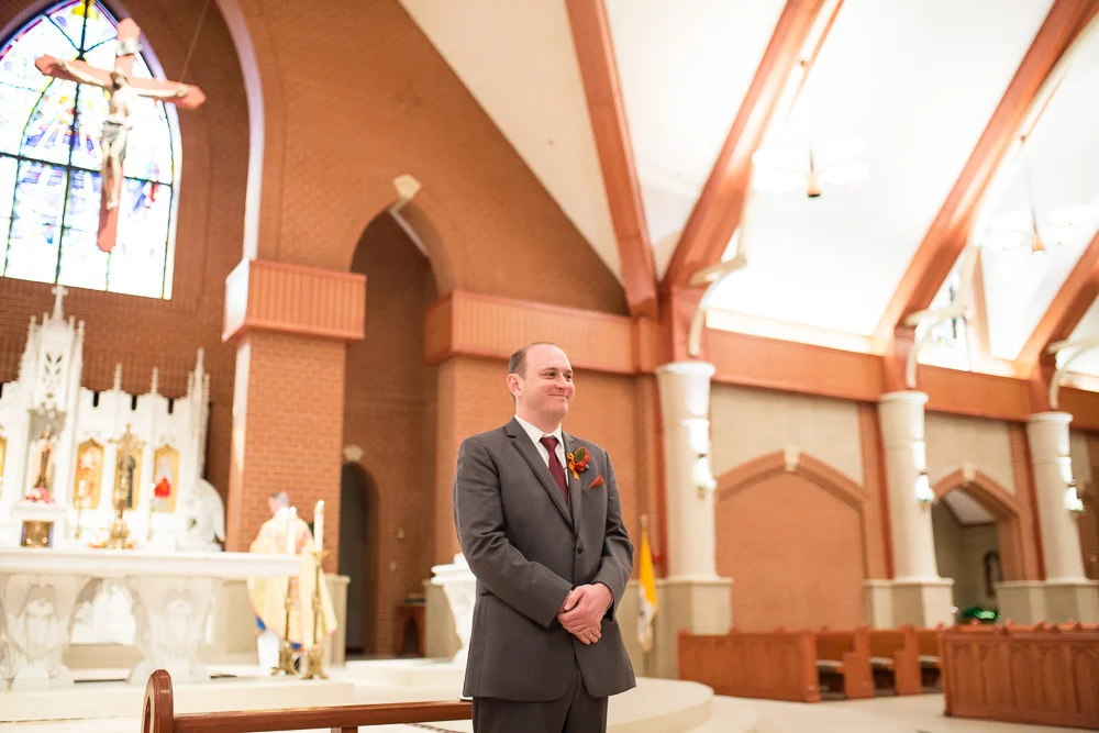 Groom watching the bride walk down the aisle at Saint Theresa’s in Ashburn | Northern Virginia Candid Wedding Photographer