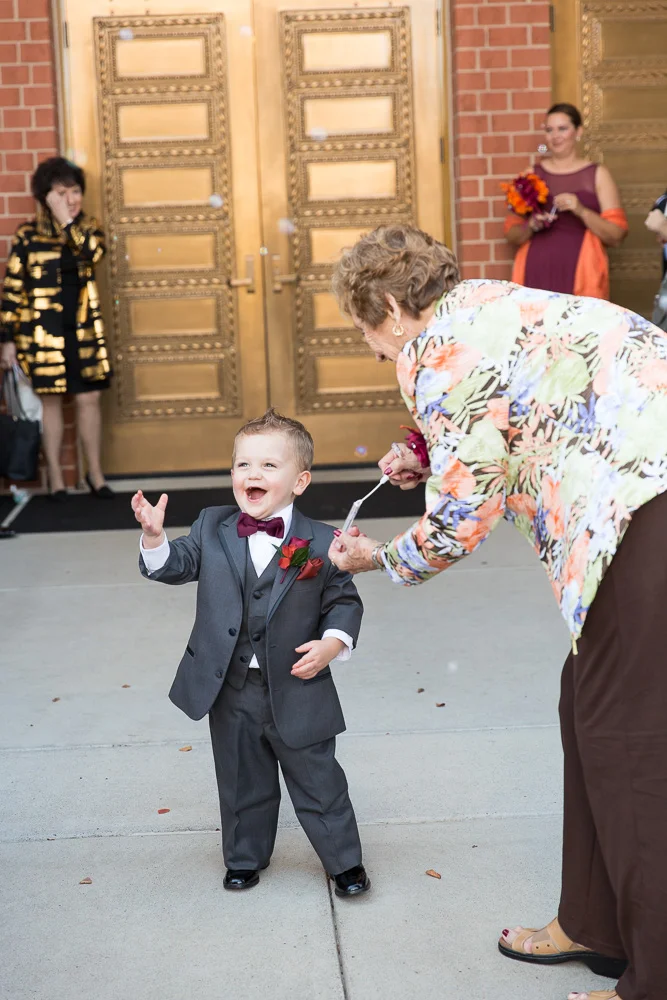 Ring bearer playing with bubbles after the wedding ceremony | Ashburn Virginia Wedding