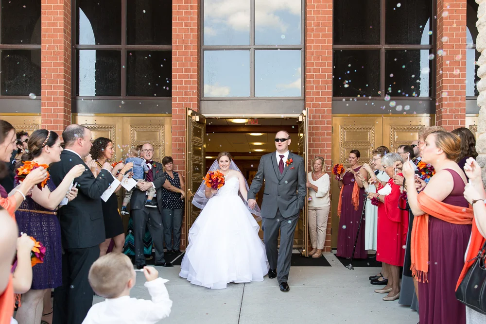 Bride and groom bubble exit from Saint Theresa Catholic Church in Ashburn, Virginia | Ashburn Virginia Wedding Photography