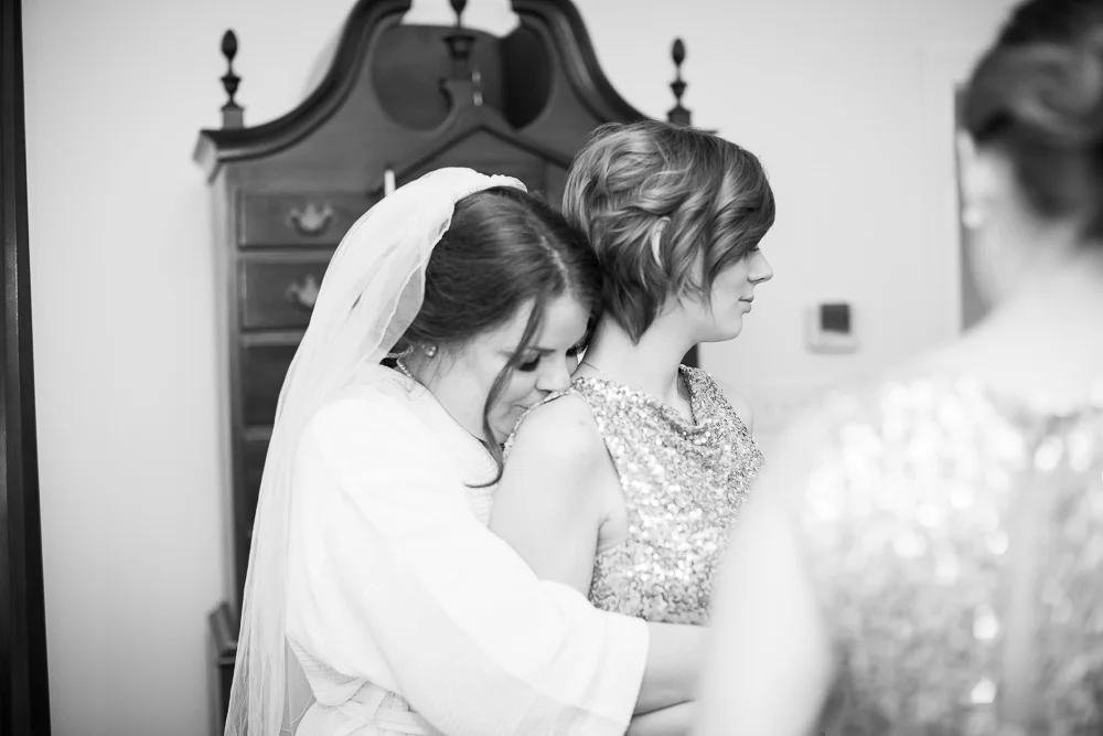 Sweet photo of bride giving her sister a kiss on the shoulder | Documentary Wedding Photographer in Richmond, Virginia