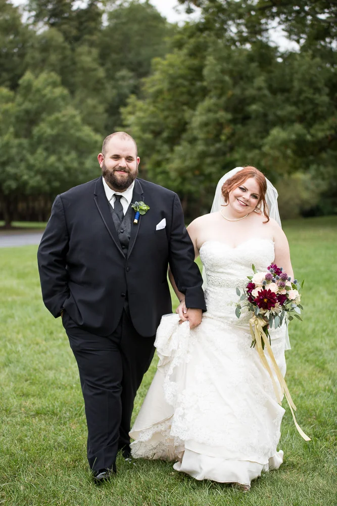 Bride and groom walking through the grass at Fox Hall Clubhouse in Richmond | Candid Wedding Photos | Megan Rei Photography