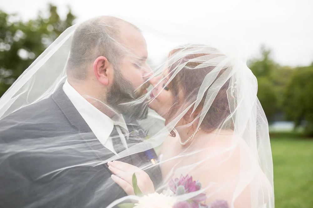 Bride and groom go in for a kiss underneath the veil | Richmond Virginia Wedding Photographer | Megan Rei Photography
