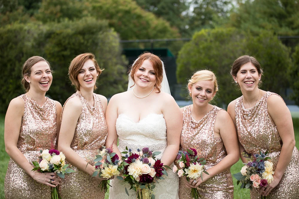 Bridal party laughing while taking pictures at Fox Hall Clubhouse in Richmond, VA