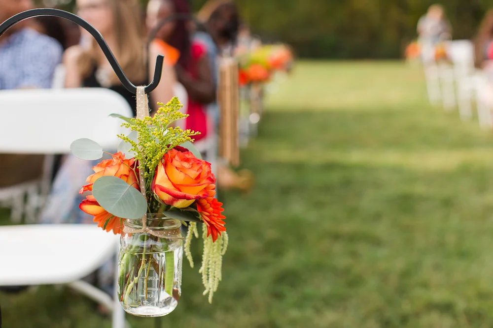 Orange flowers decorating the aisle at a Mountain Run Winery wedding | Melanie’s Florist, Haymarket Virginia