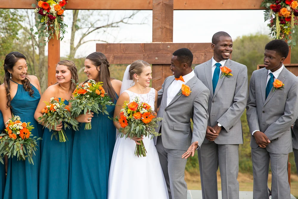 Bride and groom laughing with the bridal party