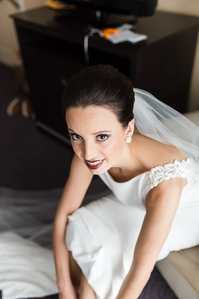 Bride putting on her Badgley Mischka heels at The Strathallan Hotel | Rochester Wedding Photography