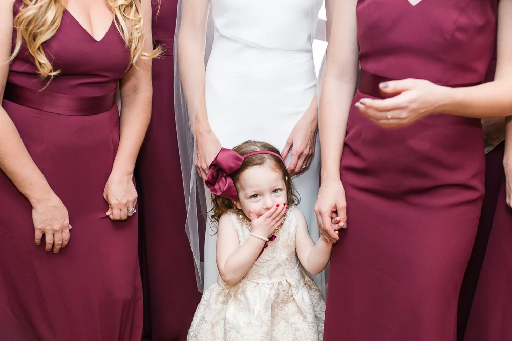 Cute flower girl with the bride and bridesmaids