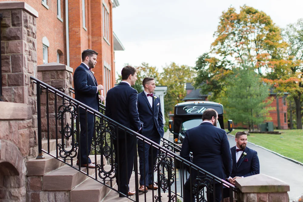 Groom and groomsmen hanging out on the front steps of Chapel Hill | Rochester Wedding Photographer