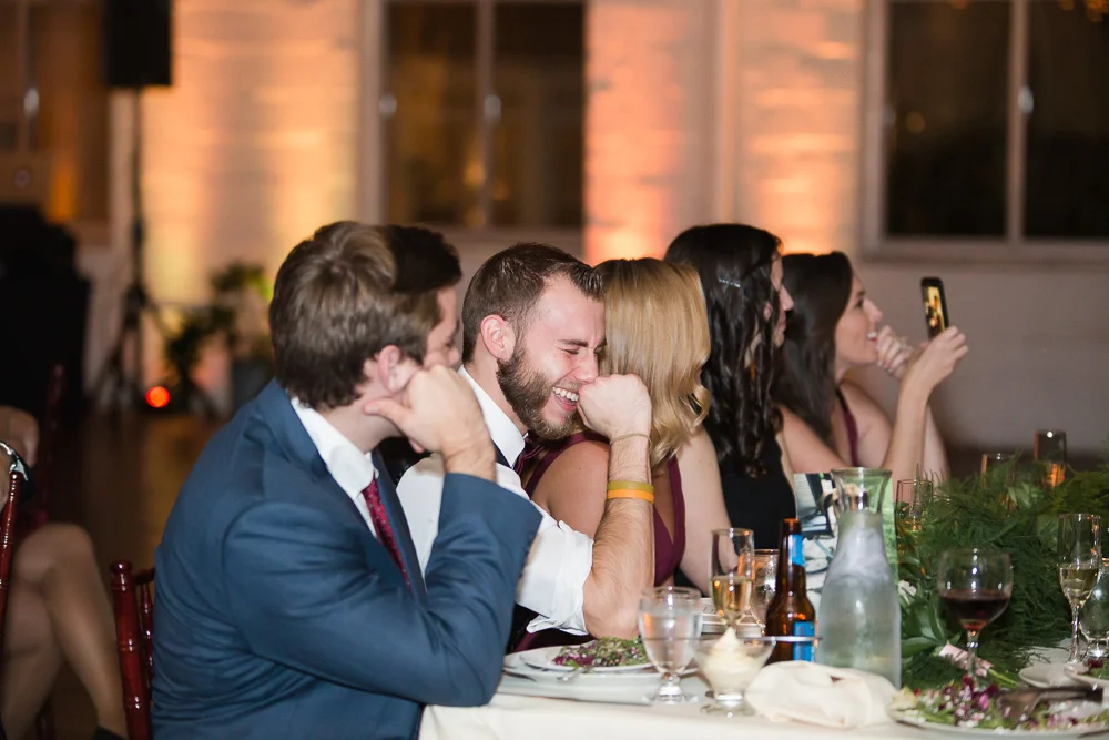 Wedding guests laughing during the toasts | Fun Wedding Photographer in Rochester, New York
