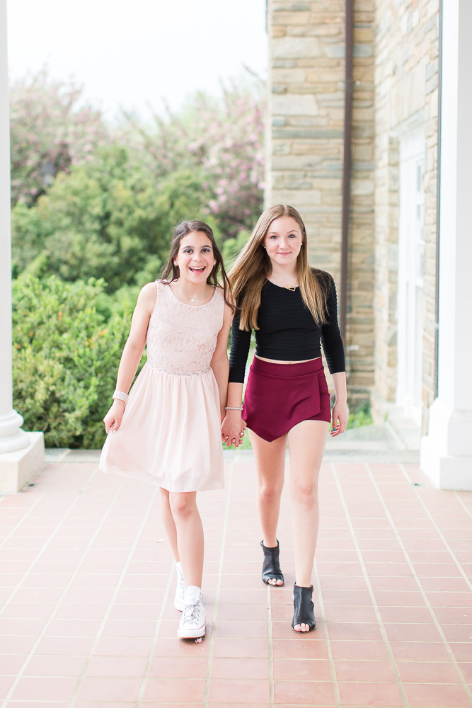 Friends holding hands on the covered front porch of the Glenview Mansion | Rockville, MD Bat Mitzvah Photography