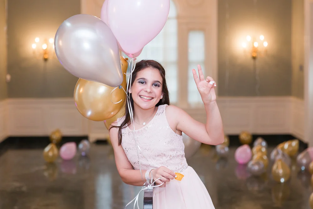 Abby posing with her balloons in front of the dance floor