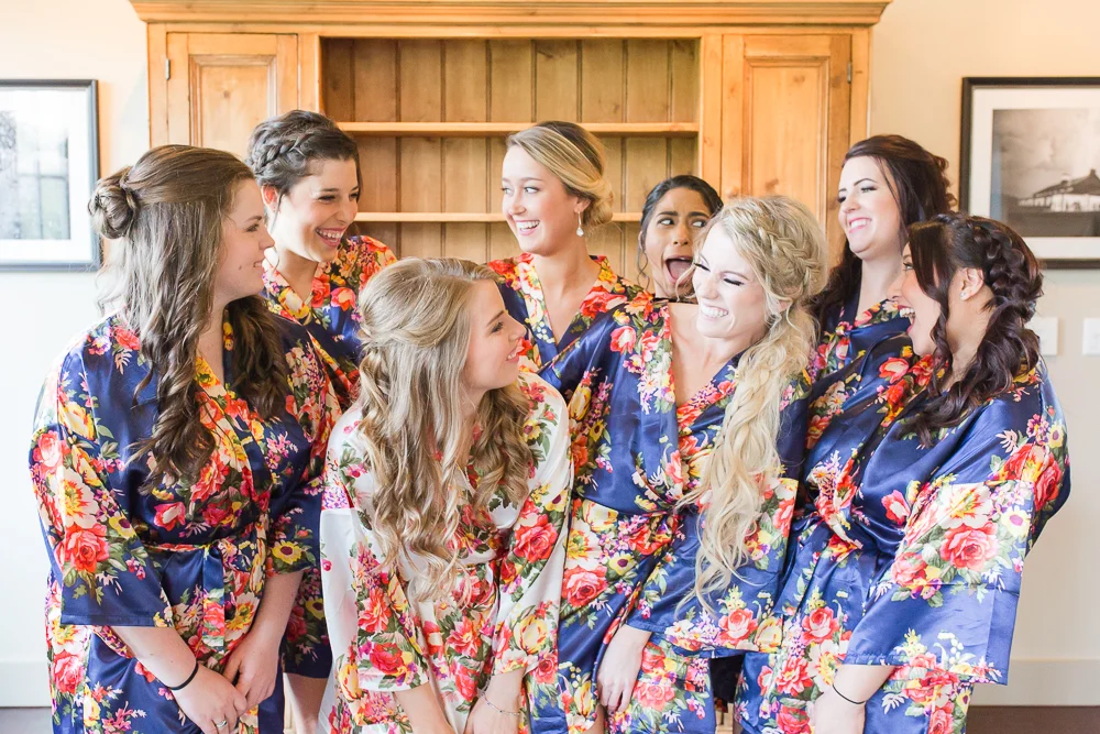 Bride with bridesmaids in matching robes while getting ready at King Family Vineyards