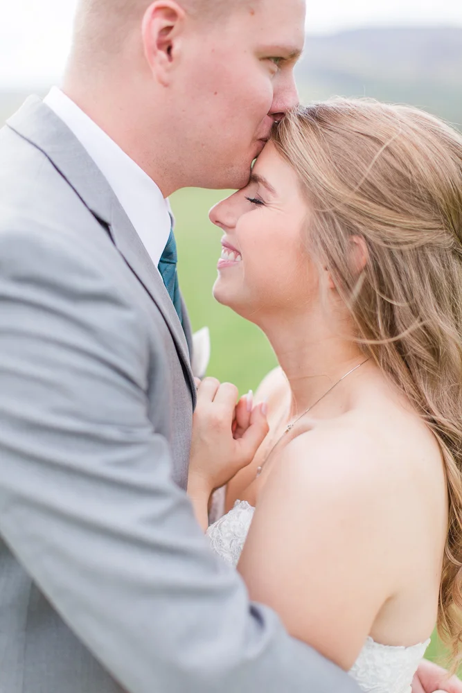 Groom giving bride a kiss on the forehead | King Family Vineyards Wedding Photos | Crozet Virginia Photographer | Megan Rei Photography