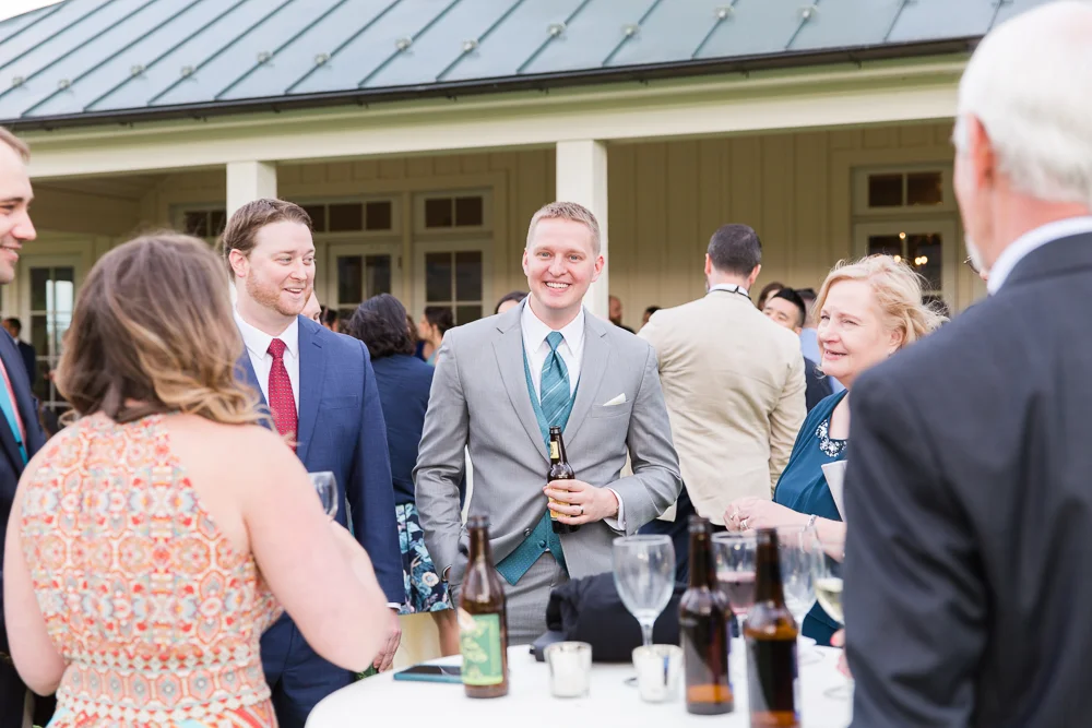 Candid picture of the groom with wedding guests during cocktail hour