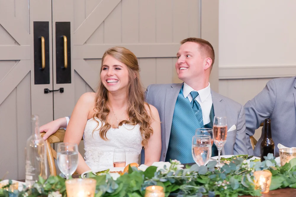 Bride and groom laughing during the wedding toasts | Candid Charlottesville Wedding Photographer