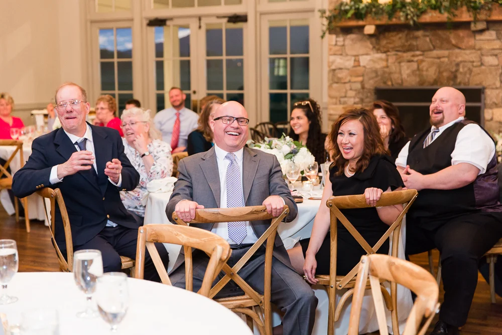 Candid picture of wedding guests laughing during the reception at King Family Vineyards | Candid Wedding Photography in Crozet