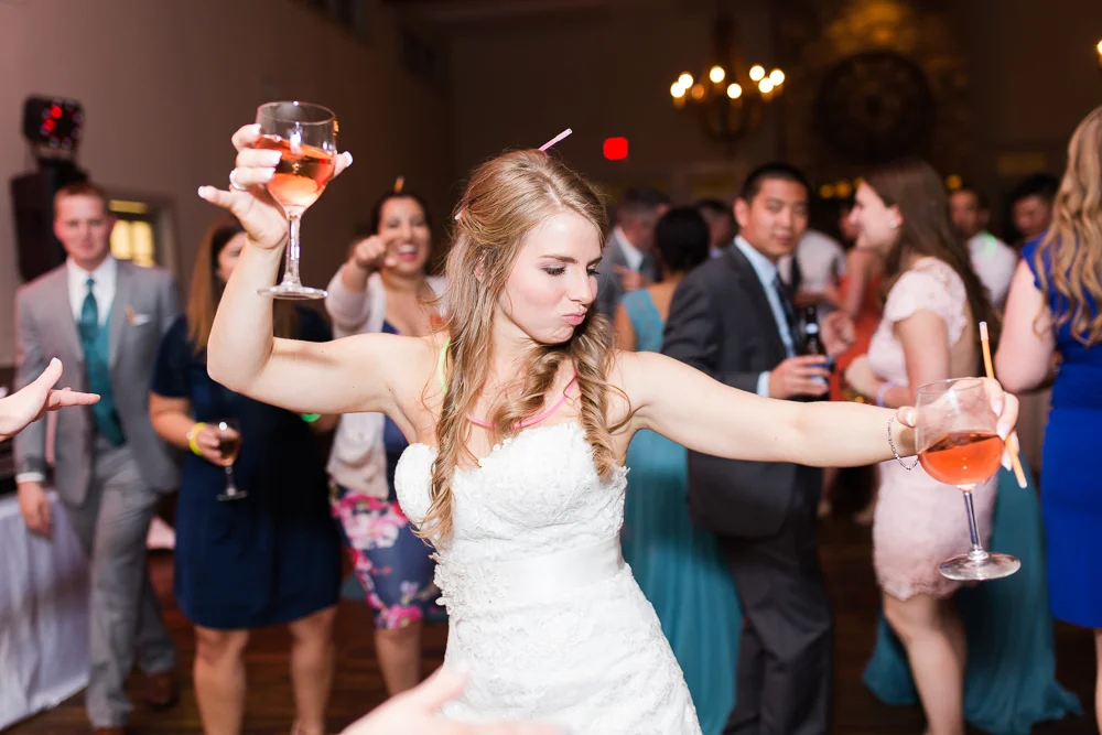 Bride dancing with two wine glasses during her wedding reception at King Family Vineyards | Fun and candid wedding photographer in Crozet, Virginia