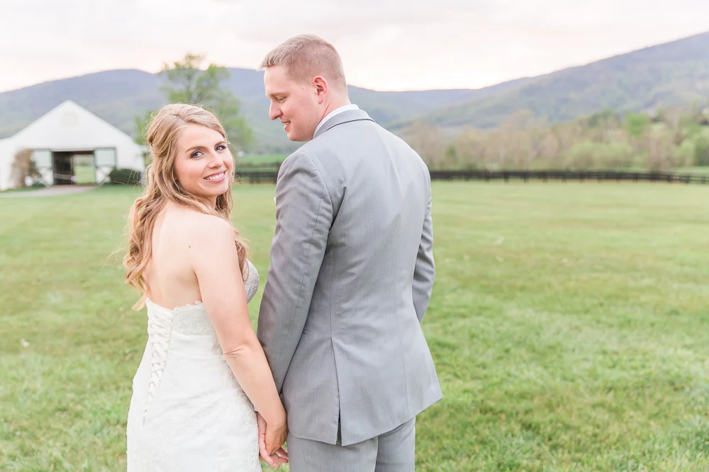 Sweet wedding photo with bride looking back at the camera | Sunset at King Family Vineyards