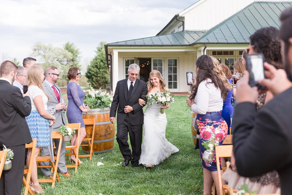 Bride and her dad walking down the aisle during wedding ceremony at King Family Vineyards | Candid Charlottesville Photographer
