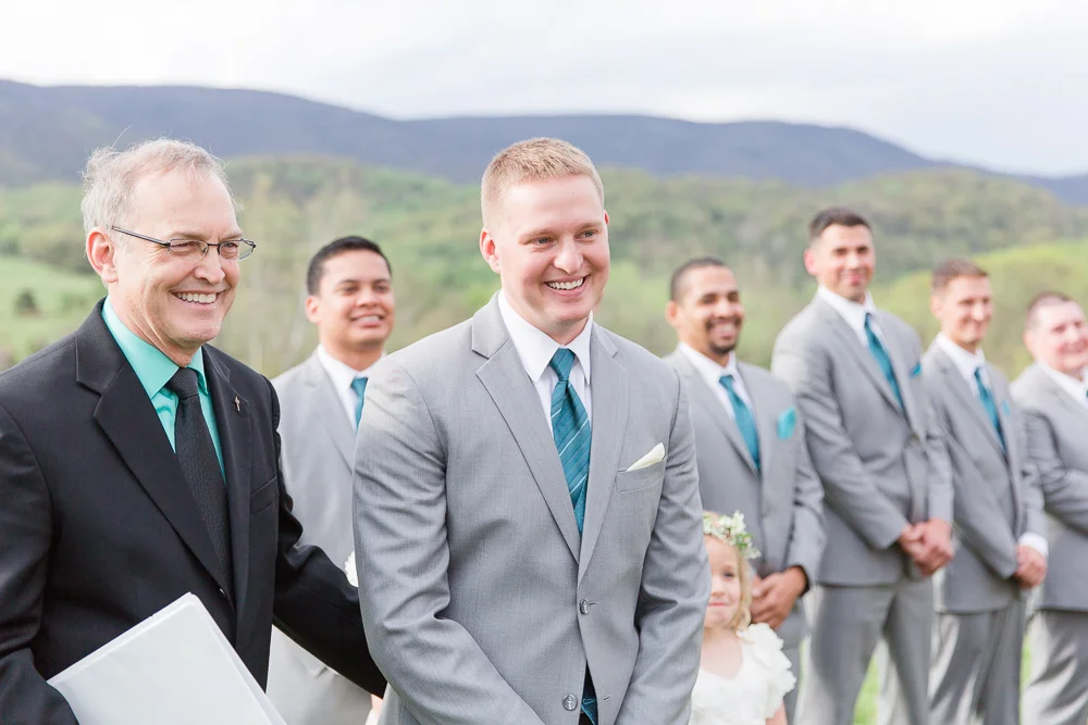 Happy groom looking at the bride at the beginning of their wedding ceremony at King Family Vineyards | Candid Charlottesville Wedding Photography