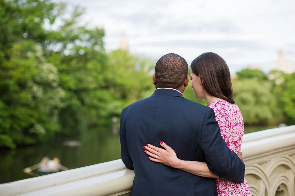 Standing on the Bow Bridge and looking down at the water | Engagement pictures in Central Park, New York City
