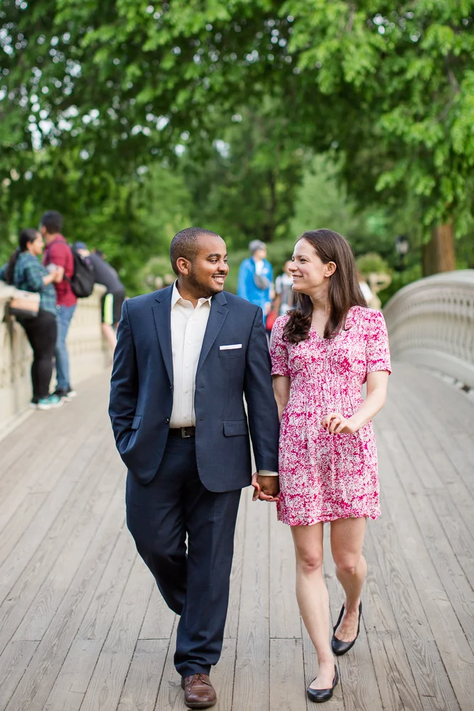 Holding hands and walking on the Bow Bridge | Best spots for engagement pictures in Central Park, New York | Megan Rei Photography