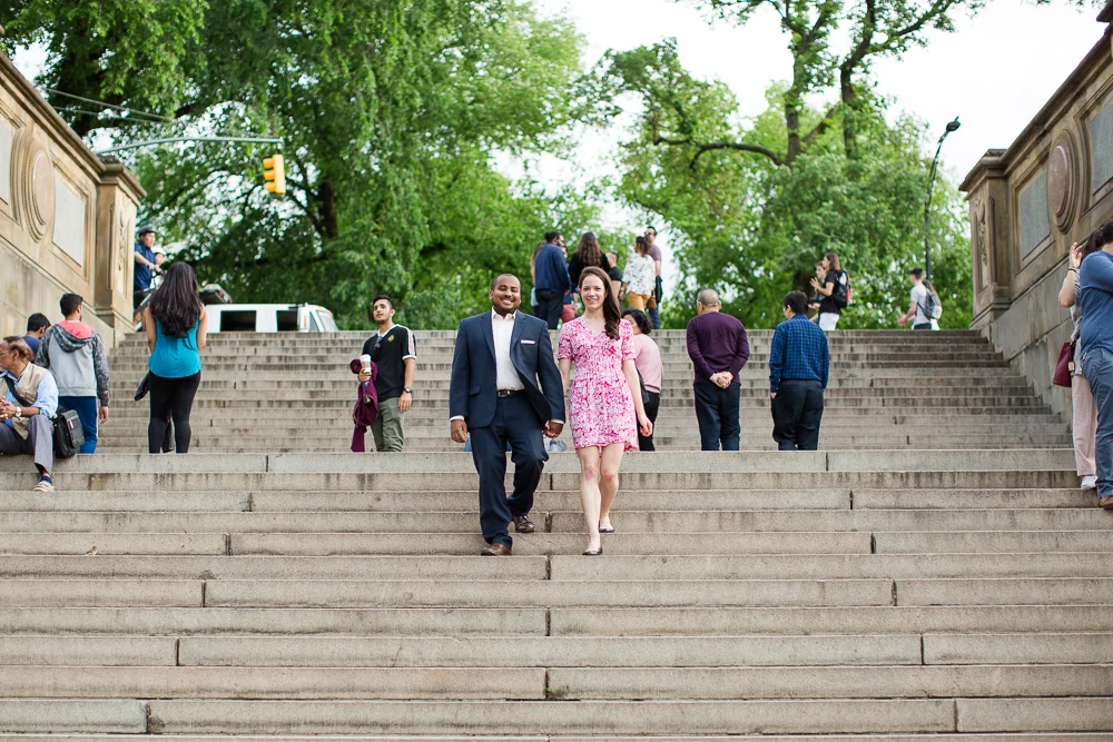 Walking down the big staircase at the Bethesda Terrace during a Central Park engagement session | Best NYC Engagement Picture Locations