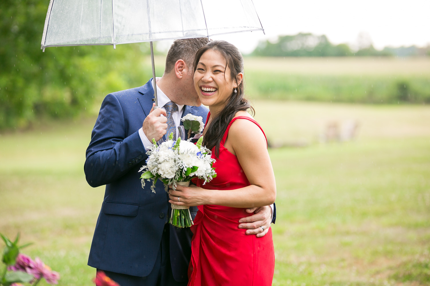 Smiling bride and groom on rainy wedding day