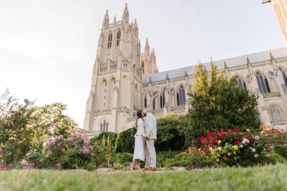  Wedding couple kisses in the garden with the National Cathedral behind them 