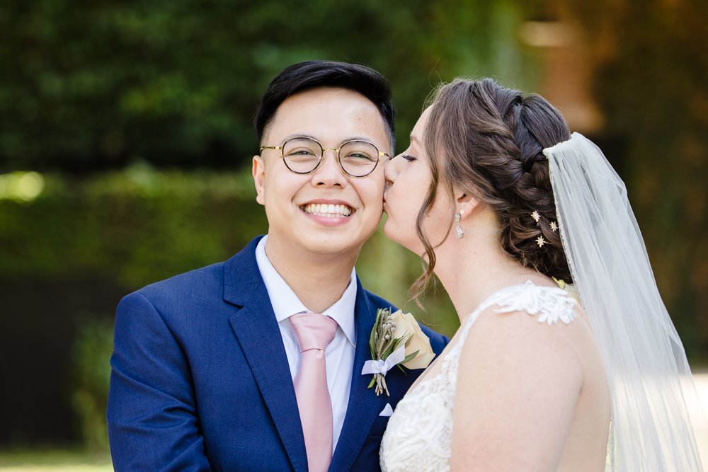 Bride kissing groom on the cheek