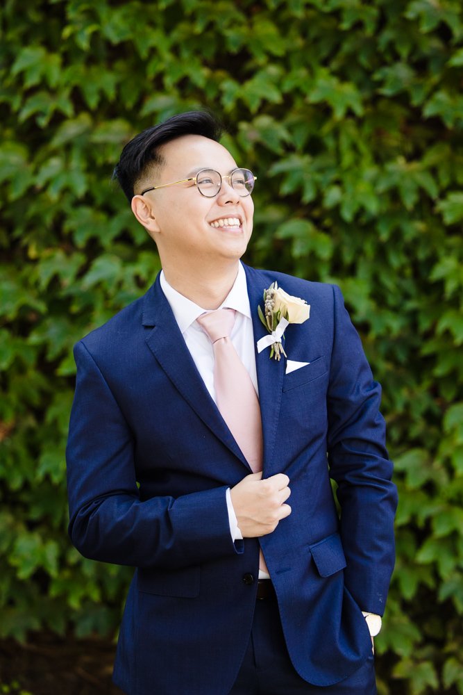 Groom portrait in front of ivy wall