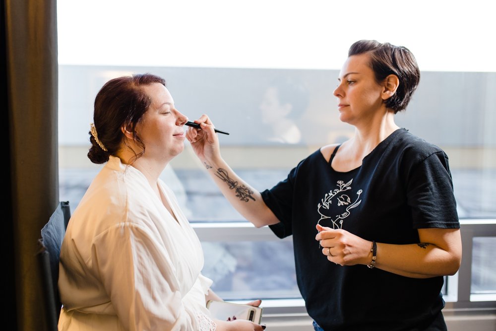 Swept LLC doing bride's makeup on the wedding day morning
