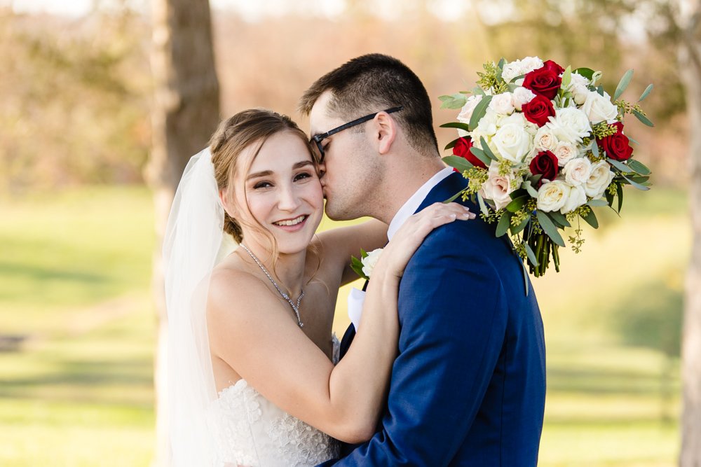 Groom kissing bride on the cheek