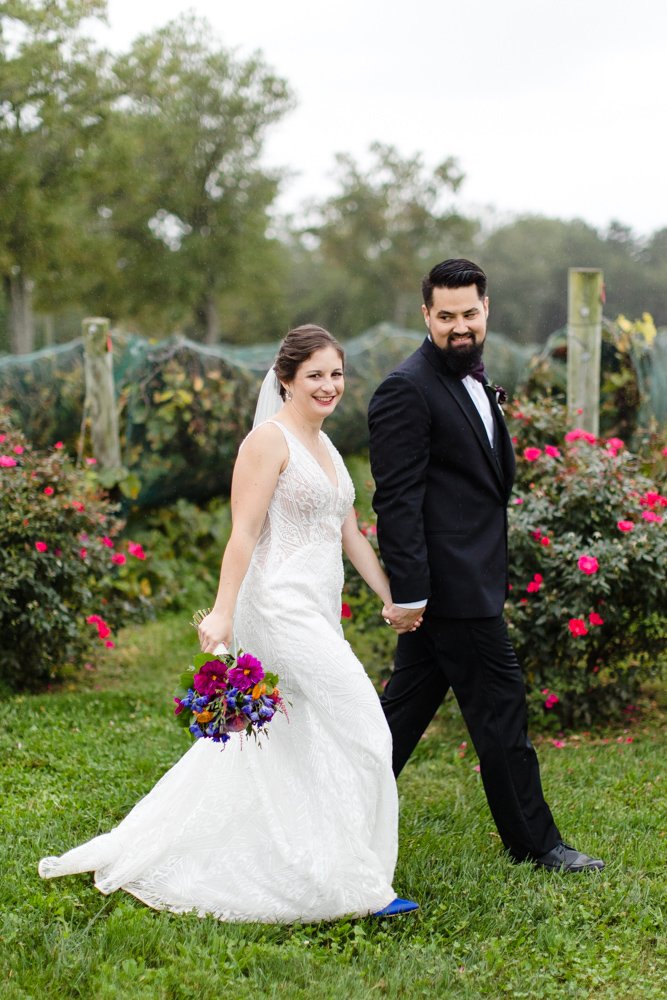 Bride and groom walking through the vineyard