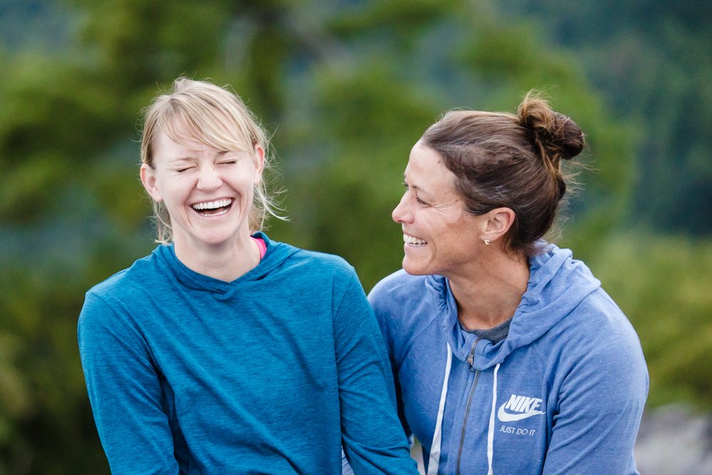 Candid LGBTQ engagement photo of two women laughing