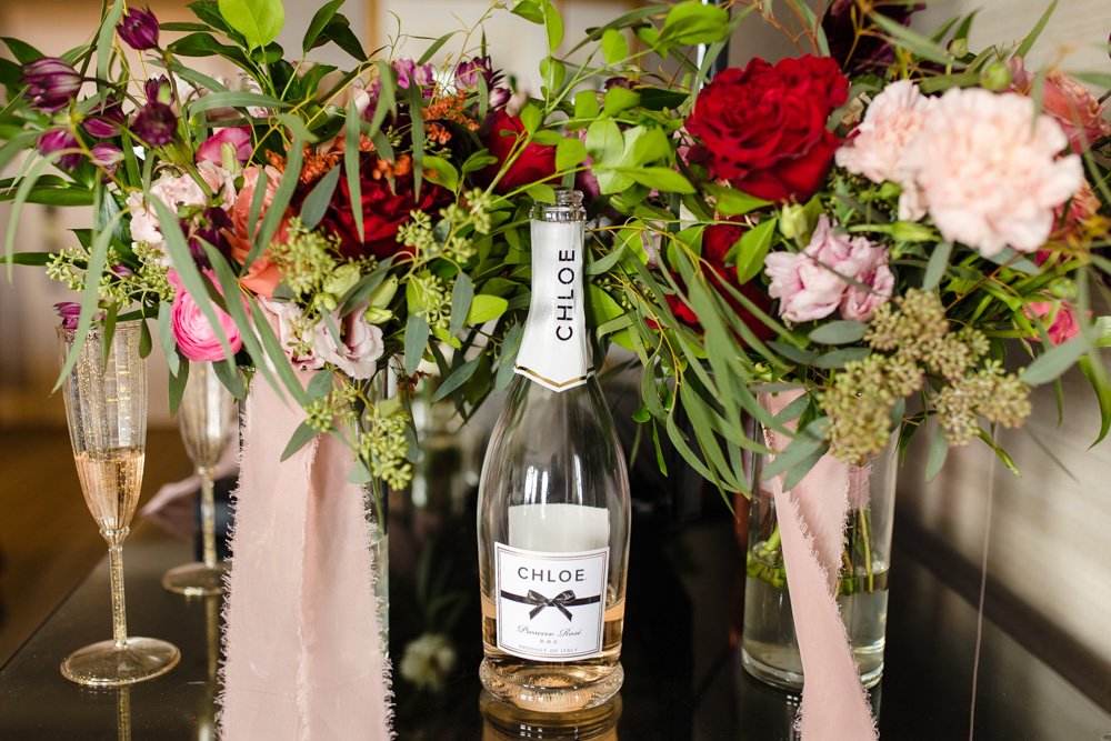 Bottle of champagne with wedding bouquets