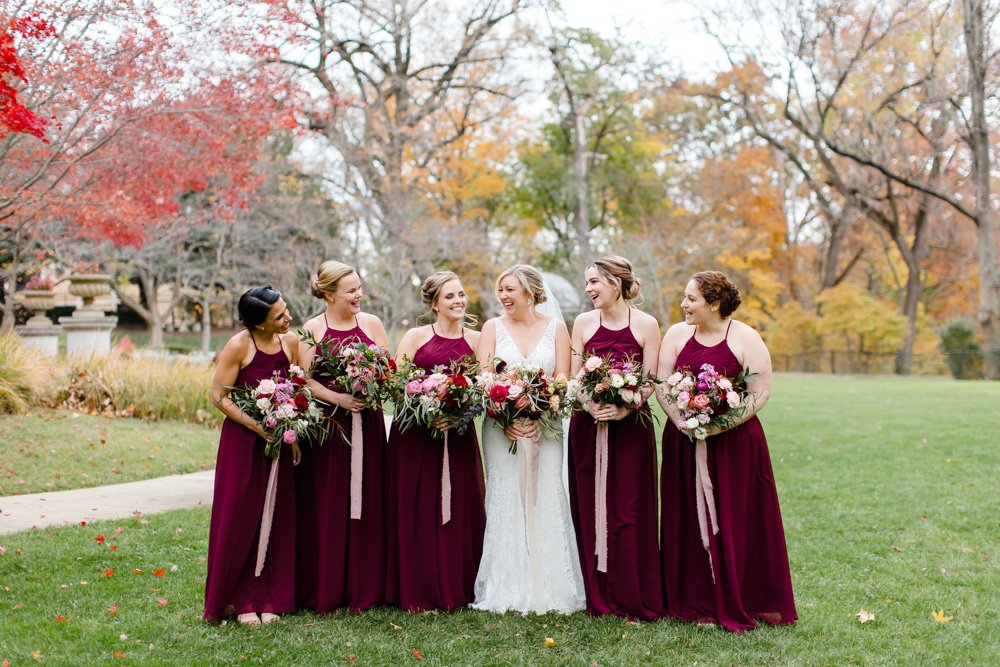 Bridesmaids in burgundy dresses on fall wedding day