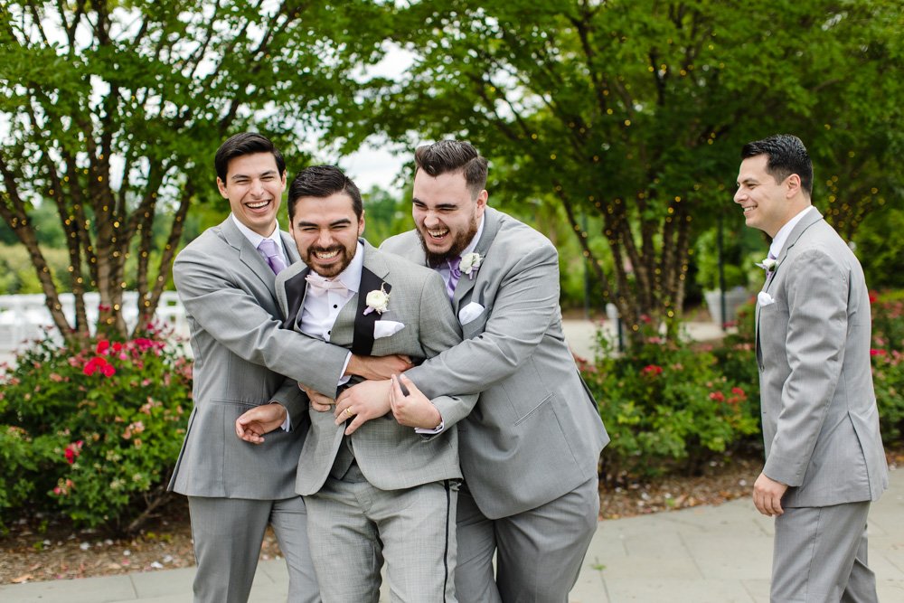 Fun picture of groomsmen hugging the groom