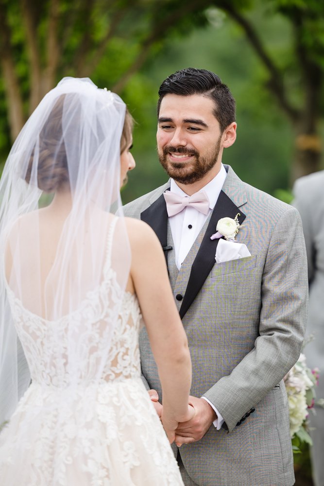 Groom smiling at bride during ceremony