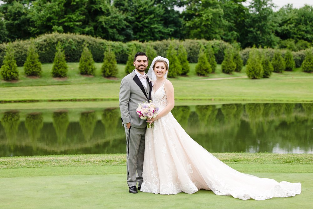 Wedding couple poses in front of the pond