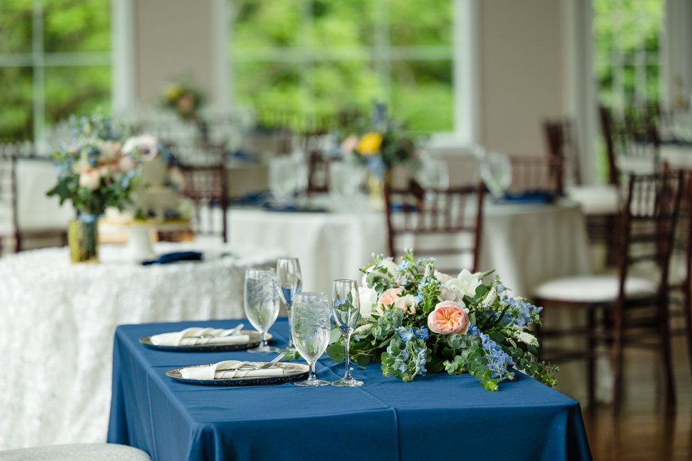  Sweetheart table with blue tablecloth and peach and blue floral arrangement 