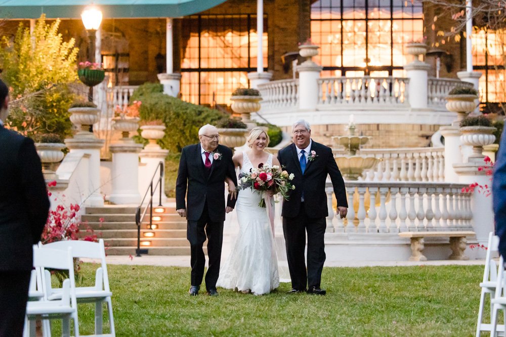 Bride walking down the aisle with dad and stepdad